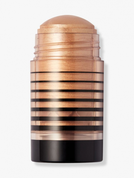 DIBS Beauty Status Stick shimmery gold body highlighter stick on light gray background