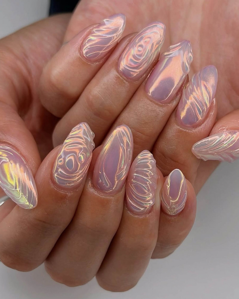 One hand cupping the other hand with nails curved up to show swirly shimmery designs.