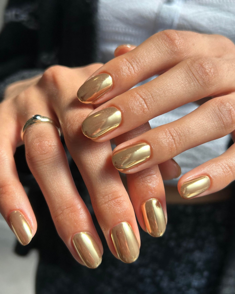 Relaxed hands facing forward with gold shimmery hue.